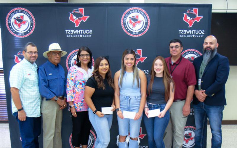 Moreno family poses with scholarship recipients and Vice President of Student Services Cruz Mata and President Hector Gonzales.